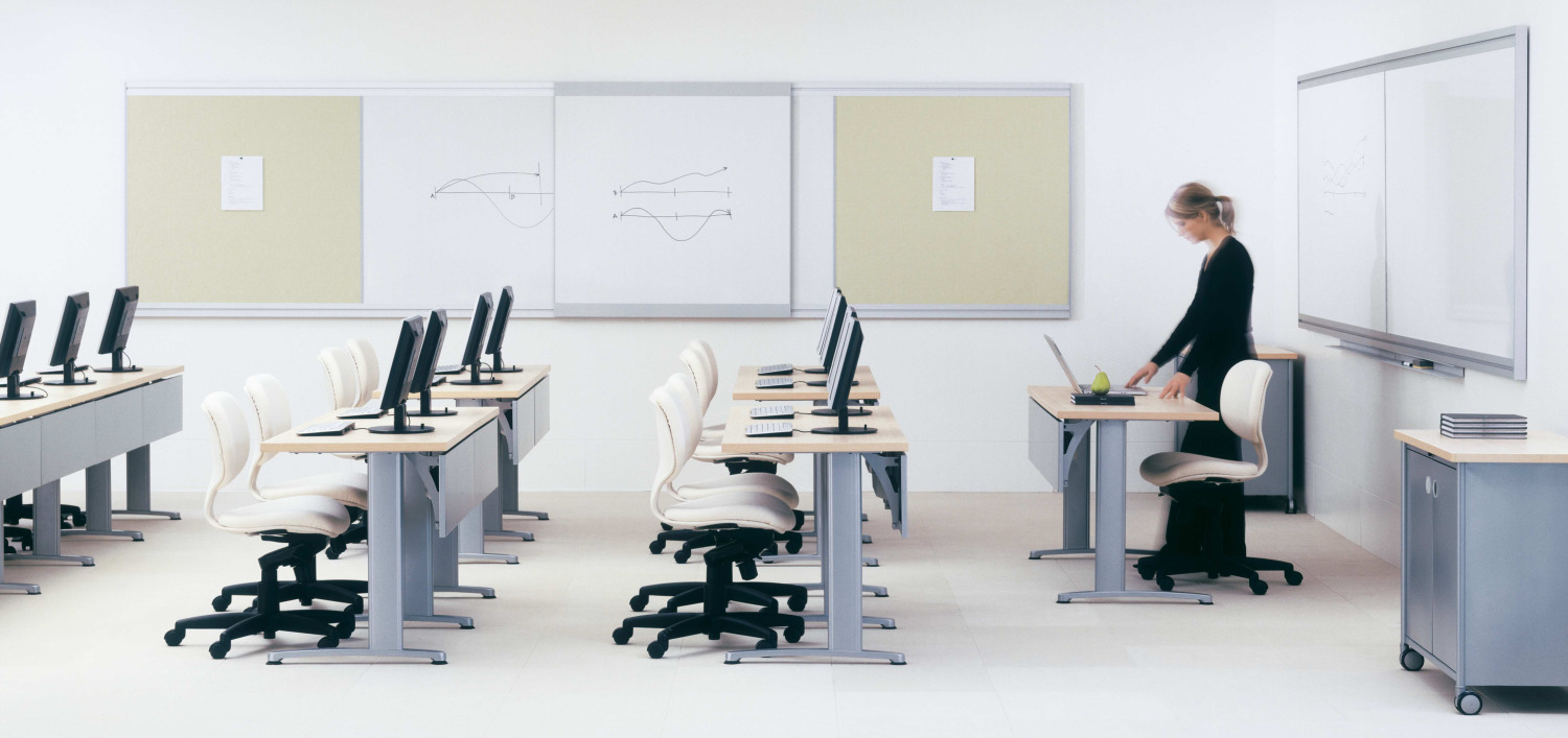 A dynamic corporate brainstorming zone in a Dubai tech office featuring professionals mapping out ideas on a large, frameless magnetic glass write-on board.