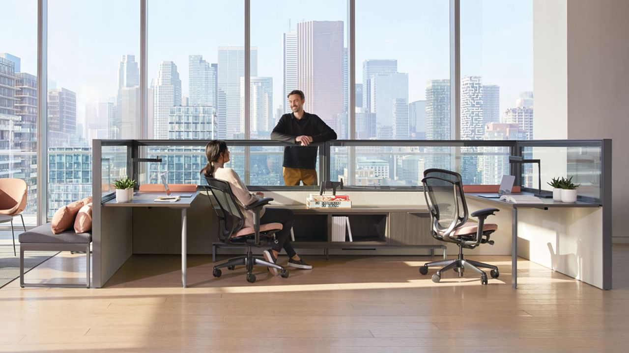 12.2.png High-performance linear workstations featuring custom color-matched privacy screens and ergonomic task seating in a branded Dubai office space.