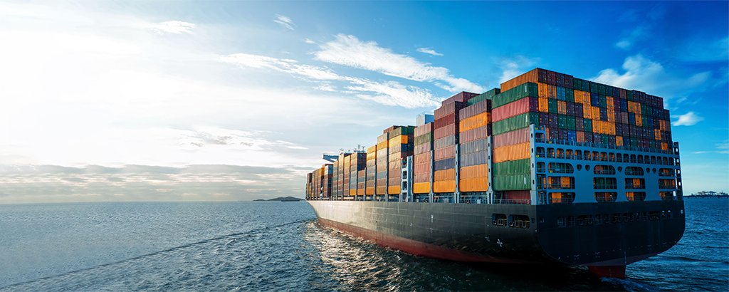 An international cargo vessel navigating commercial shipping lanes, symbolizing the complex global supply chain for office furniture imports into the GCC.